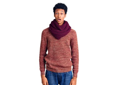 Genç Afro-Amerikan adam günlük kazak ve eşarp giyiyor. Korkuyor ve şok geçiriyor. Şaşırıyor ve şaşırıyor.. 