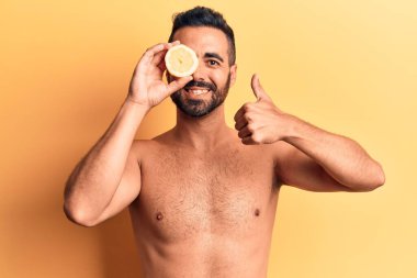 İspanyol asıllı genç adam limonsuz, mutlu ve pozitif gülümseyen, başparmağıyla mükemmel ve onay işareti yapıyor. 