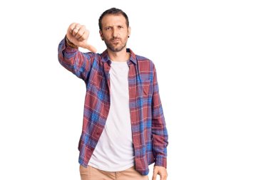 Gündelik kıyafetler giyen, mutsuz görünen, reddedilmiş ve olumsuz davranan genç yakışıklı bir adam. kötü ifade. 