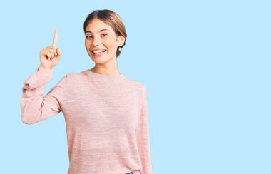 Sarışın, kışlık süveter giyen beyaz güzel bir kadın başarılı bir fikri işaret ediyor. Heyecanlı ve mutlu. Bir numara.. 