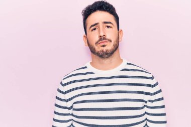 Yüzünde ciddi bir ifade olan günlük kıyafetler giyen genç bir İspanyol. Basit ve doğal bir şekilde kameraya bakıyorsun.. 