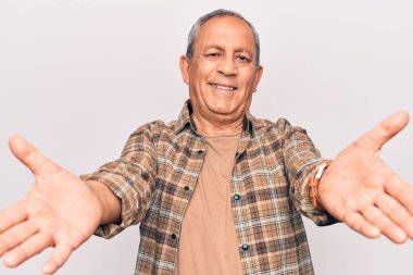 Gri saçlı, sıradan gömlekli son sınıf öğrencisi kameraya bakıp sarılmak için kollarını açmış gülümsüyor. Mutluluğu kucaklayan neşeli bir ifade.. 