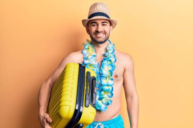 Mayolu yakışıklı ve kel bir adam ve elinde kamara çantası olan Hawai zambağı tutan pozitif ve mutlu görünüyor ve gülümsüyor. 