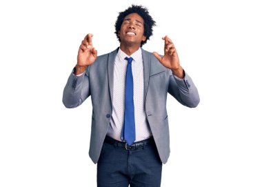 Afro saçlı, iş ceketi giyen yakışıklı Afro-Amerikalı. Umut ve gözlerin kapalı bir şekilde gülümseyerek el işareti yapıyor. Şans ve batıl inançlar. 