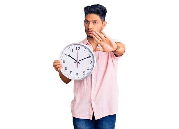 Guapo Joven Latinoamericano Sosteniendo Gran Reloj Con Mano Abierta Haciendo —  Fotos de Stock