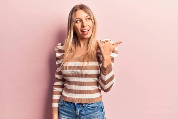 Ung Blondine Kvinde Iført Afslappet Tøj Peger Tommelfinger Til Siden - Stock-foto