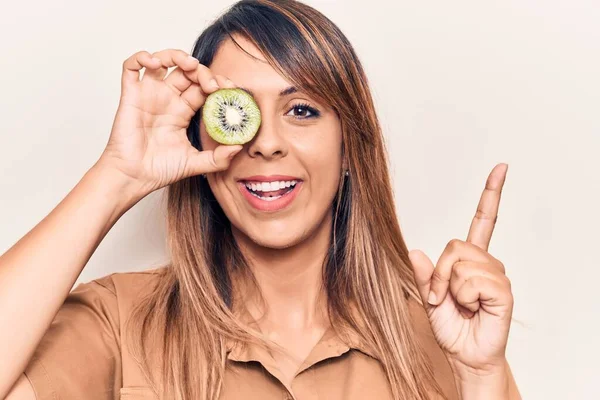 Jovem Mulher Bonita Segurando Kiwi Sobre Olho Sorrindo Feliz Apontando — Fotografia de Stock