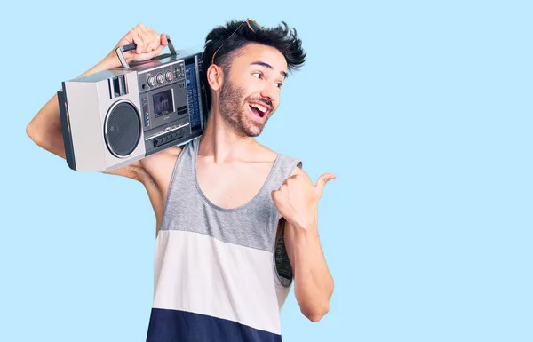 Joven Hispano Sosteniendo Boombox Escuchando Música Apuntando Con Pulgar Hacia —  Fotos de Stock