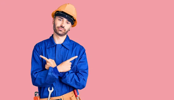 Jovem Hispânico Homem Vestindo Trabalhador Uniforme Apontando Para Ambos Lados — Fotografia de Stock