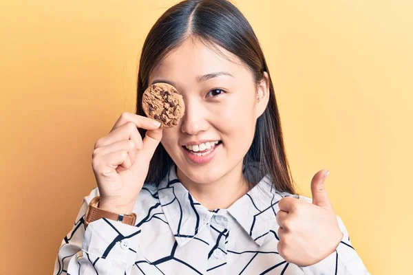 Joven Hermosa Mujer China Sosteniendo Galleta Sobre Ojo Sonriendo Feliz —  Fotos de Stock