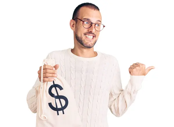 Jovem Homem Bonito Segurando Saco Dinheiro Com Símbolo Dólar Apontando — Fotografia de Stock