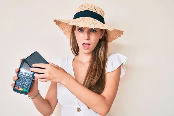 Młoda Blondynka Płaci Smartfonem Dataphone Szoku Twarzy Patrząc Sceptyczny Sarkastyczny — Zdjęcie stockowe