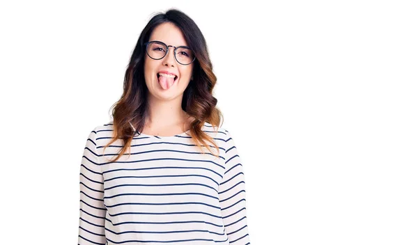 Piękna Młoda Brunetka Ubrana Luźne Ubrania Okulary Wystające Język Szczęśliwy — Zdjęcie stockowe