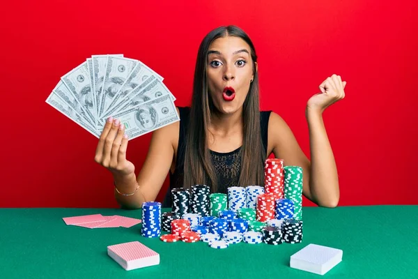 Νεαρή Ισπανόφωνη Γυναίκα Που Παίζει Πόκερ Κρατώντας Χαρτονομίσματα Δολαρίων Φοβισμένη — Φωτογραφία Αρχείου