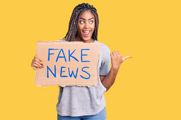 Young African American Woman Braids Holding Fake News Banner Pointing — ストック写真