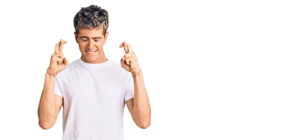 Young Handsome Man Wearing Casual White Tshirt Gesturing Finger Crossed — Stock Photo, Image