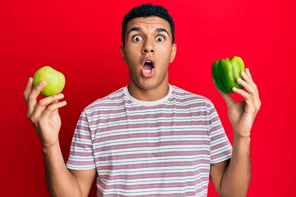 Hombre Árabe Joven Sosteniendo Manzana Verde Pimienta Asustado Sorprendido Con —  Fotos de Stock