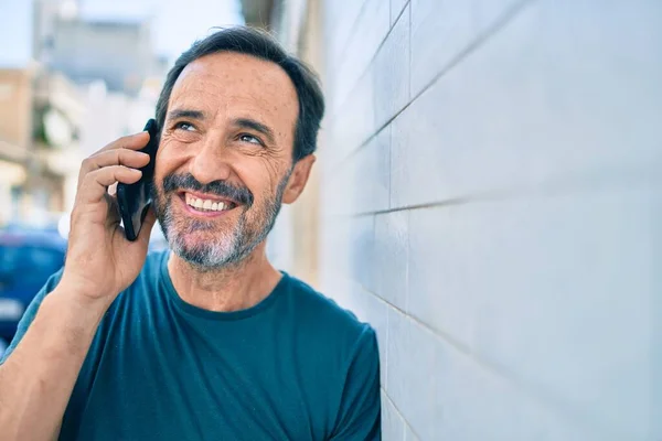 中年男子留着胡子 在户外快乐地微笑着 在电话里说话 — 图库照片