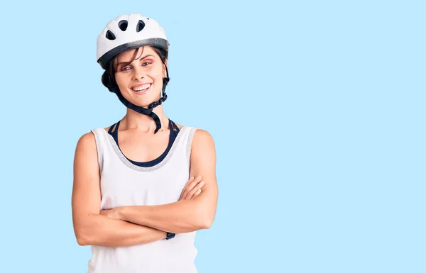 Beautiful young woman with short hair wearing bike helmet happy face smiling with crossed arms looking at the camera. positive person.