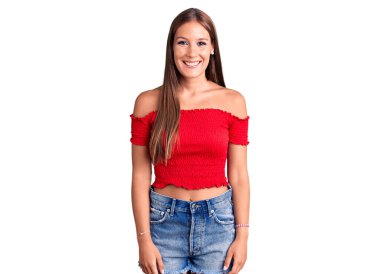 Genç, güzel, İspanyol bir kadın mutlu ve havalı bir gülümsemesi olan gündelik kıyafetler giyiyor. şanslı kişi. 