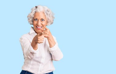 Gri saçlı, günlük kıyafetler giyen, mutlu ve komik yüzlü yaşlı bir kadın. iyi enerji ve titreşimler. 