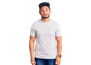 Yakışıklı Latin Amerikalı, sıradan tişörtler giyen komik yüzlü yanakları şişiren genç adam. Havayla şişmiş ağız, çılgın bir ifade.. 