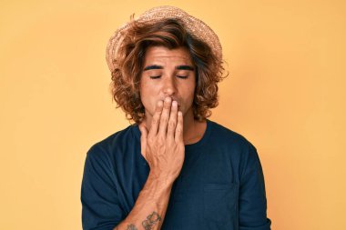 Yaz şapkası takan İspanyol genç adam ağzıyla esnemekten sıkıldı. Huzursuz ve uykulu.. 