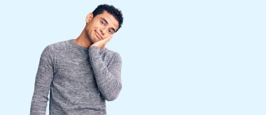 İspanyol asıllı yakışıklı genç adam sıradan bir süveter giyip kollarını kavuşturarak depresyondan sıkılmış ve yorgun görünüyor.. 