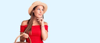 Yaz şapkası takan ve elinde piknik sepeti tutan genç, İspanyol bir kadın. Ciddi bir yüzle eli çenesinde soru sormayı düşünüyor. Kafa karıştırıcı bir fikir. 