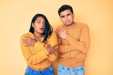Güzel Latin genç çift, günlük kıyafetlerini giyip kış soğuğu için titriyor ve donuyor. Yüzlerinde üzgün ve şok ifadesi var. 