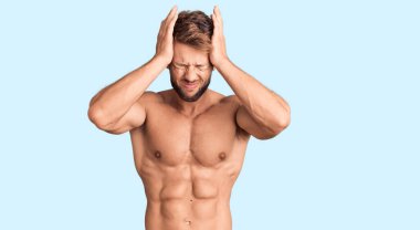 Kafkasyalı genç adam başağrısı yüzünden üstsüz, çaresiz ve stresli. Çünkü acı ve migren. Eller başının üstünde.. 