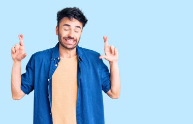 Günlük kıyafetler giyen genç İspanyol adam umut ve gözlerin kapalı gülümseyerek bana işaret etti. Şans ve batıl inançlar. 