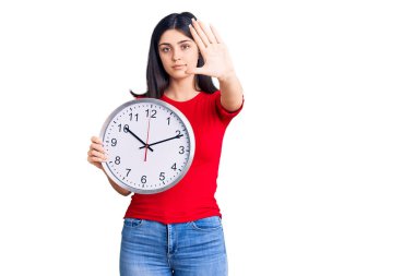 Saati açık tutan genç ve güzel bir kız dur işareti yapıyor. Ciddi ve kendinden emin bir ifadeyle, savunma hareketi yapıyor. 