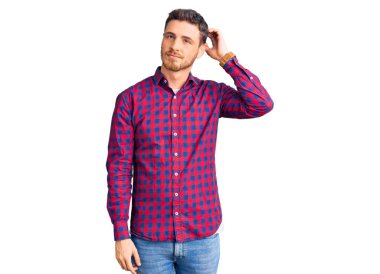 Sıradan gömlekler giyen yakışıklı genç adam soru sormayı merak ediyor. Şüpheyle kararsız, kafa kafaya düşünerek. Düşünceli kavram. 