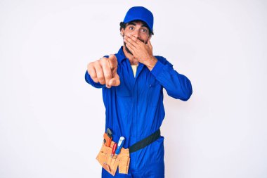 Kıvırcık saçlı ve ayı gibi giyinen yakışıklı genç adam sana gülüyor, eli ağzında kamerayı işaret ediyor, utanç ifadesi takınıyor. 