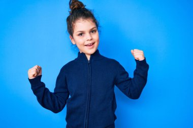 Hoş İspanyol çocuk gündelik kıyafetler giyip gururla bağırıyor zaferi ve başarıyı kutluyor. Kollarını kaldırıp heyecanla bekliyor. 