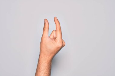 İzole edilmiş beyaz arka plan üzerinde parmaklarını gösteren beyaz bir adamın eli. Görünmez bir şeyi alıp, parmaklarıyla uzayı gösteren bir nesneyi tutuyor.