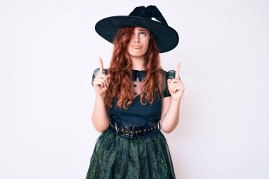 Cadılar Bayramı kostümü giymiş genç ve güzel bir kadın üzgün ve üzgün görünüyor, parmaklarıyla yön gösteriyor, mutsuz ve depresif.. 