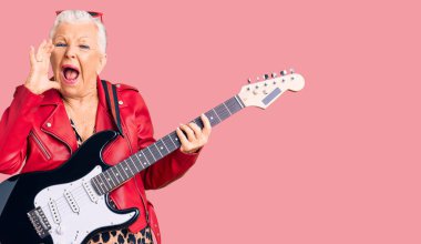 Son sınıf güzeli, mavi gözlü, gri saçlı, modern görünümlü, elektro gitar çalan, el üstünde ağızla bağıran ve yüksek sesle bağıran bir kadın. iletişim konsepti. 