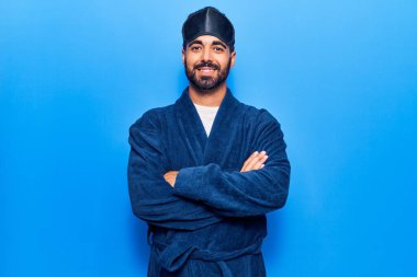 Uyku maskesi takan ve kollarını kavuşturup kameraya gülümseyen İspanyol bir adam. pozitif kişi. 