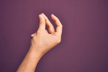 İzole edilmiş mor arka planda parmaklarını gösteren beyaz bir genç adam. Başarı için parmaklarını şıklatıyor, kolay ve elinle sembolü tıklatıyor.