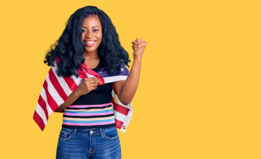 Güzel afro-amerikan bayrağı tutan kadın gururla bağırıyor, zaferi ve başarıyı kutluyor. 