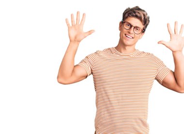 Genç, yakışıklı, günlük kıyafetler ve gözlük takan on numaralı parmaklarıyla onu gösterirken kendinden emin ve mutlu bir şekilde gülümseyen adam.. 