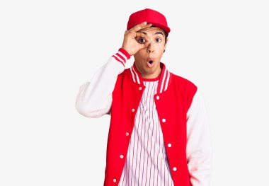 Beyzbol üniforması giyen genç Afro-Amerikan bir adam şaşırmış yüz ifadesiyle şaşırmış, parmaklarından bakan bir jest yapıyor. İnançsız ifade. 