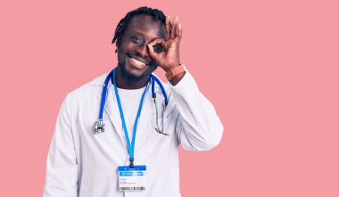 Doktor steteskop ve kimlik kartı takan genç Afrikalı Amerikalı adam gülümsüyor. 