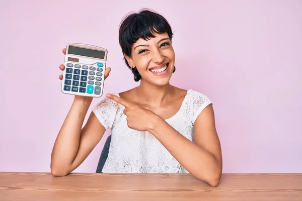 Красива Брюнетка Жінка Показує Калькулятор Пристрій Усміхнений Щасливий Вказуючи Рукою — стокове фото