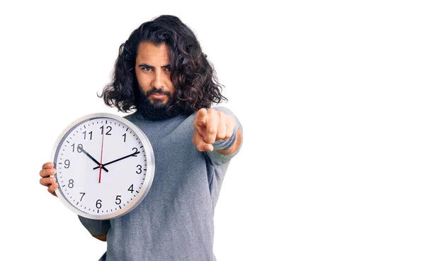 Hombre Árabe Joven Sosteniendo Gran Reloj Apuntando Con Dedo Cámara —  Fotos de Stock