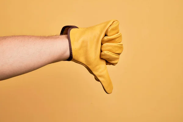 Mão Homem Jovem Caucasiano Com Luva Jardineiro Sobre Fundo Amarelo — Fotografia de Stock