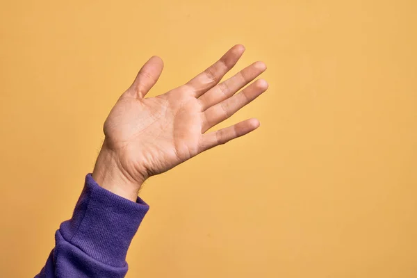 孤立した黄色の背景の上に指を示す白人の若者の手は オープン手のひらで提示 サポートとヘルプのために到達 支援ジェスチャー — ストック写真