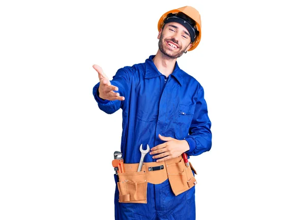 Joven Hombre Hispano Vistiendo Uniforme Obrero Sonriente Alegre Ofreciendo Mano — Foto de Stock